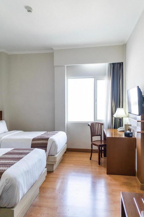 Image de la chambre comprenant un lit, un bureau et une télé